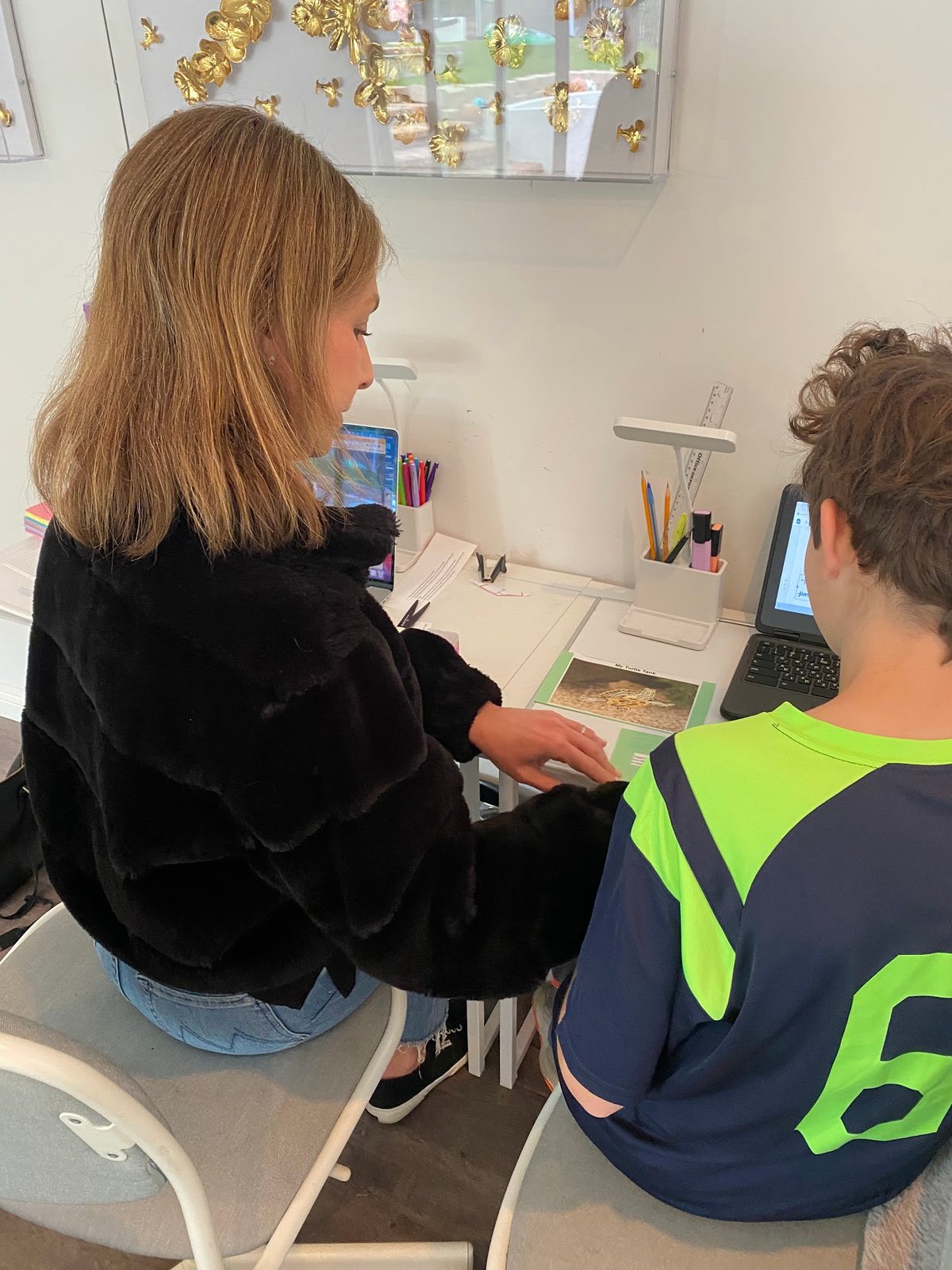A tutor working one-on-one with a student on laptops during a tutoring session